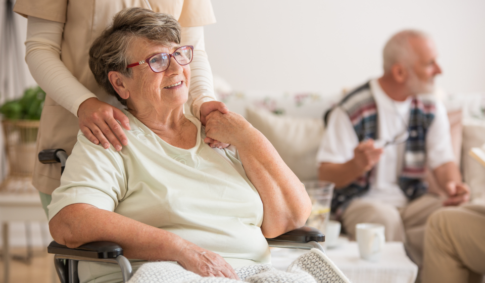 Une personne âgée assise en fauteuil roulant dans une maison de retraite