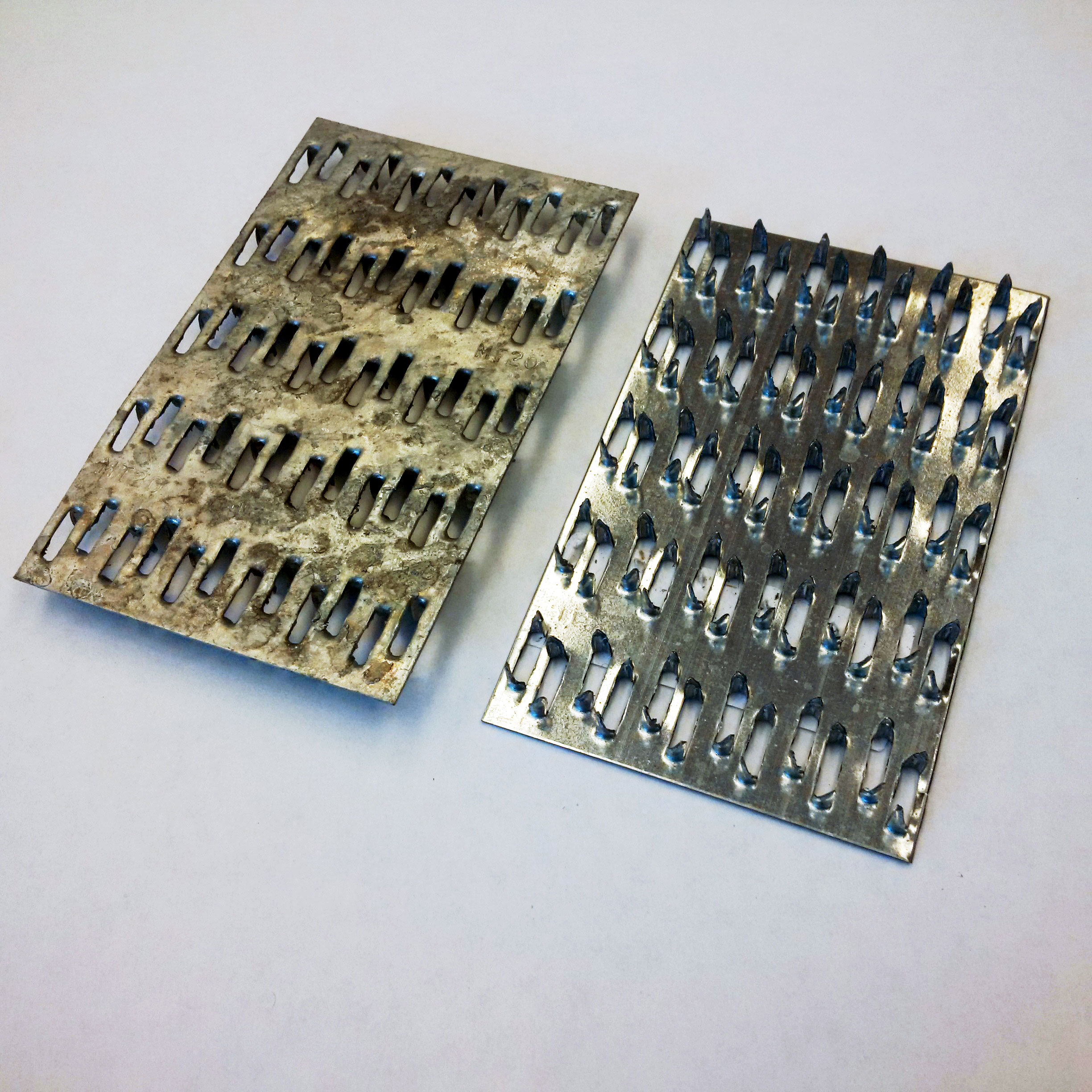 Two examples of connector plates, to illustrate the protrusions or teeth from punching during fabrication. Also shown is the visual difference in finish between using pre-galvanized plate and galvanizing after plate fabrication.