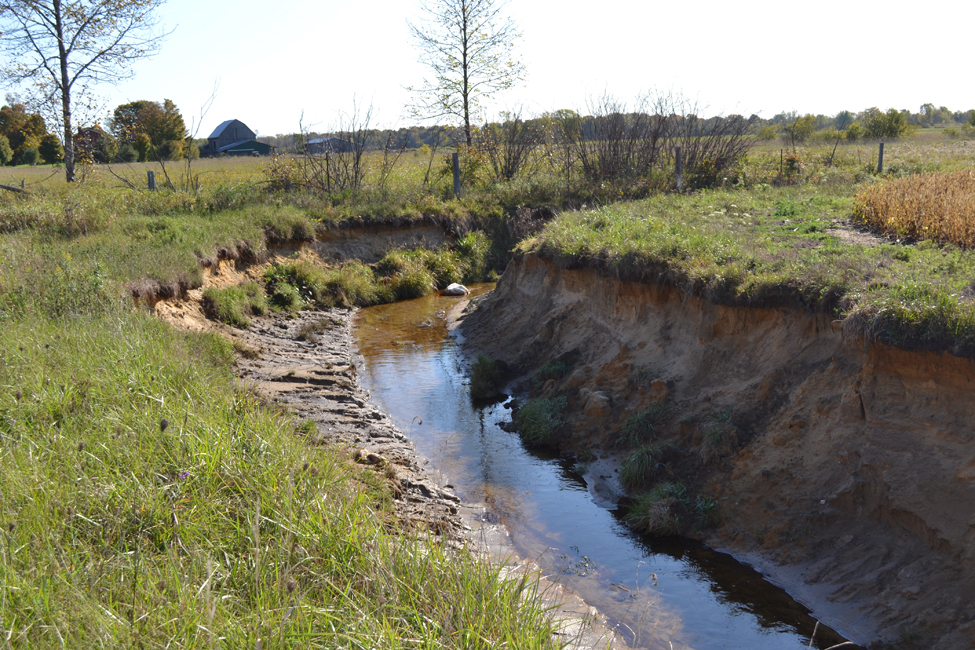 Photo montrant un canal de drainage érodé et le sapement et l’affouillement subis par ses berges