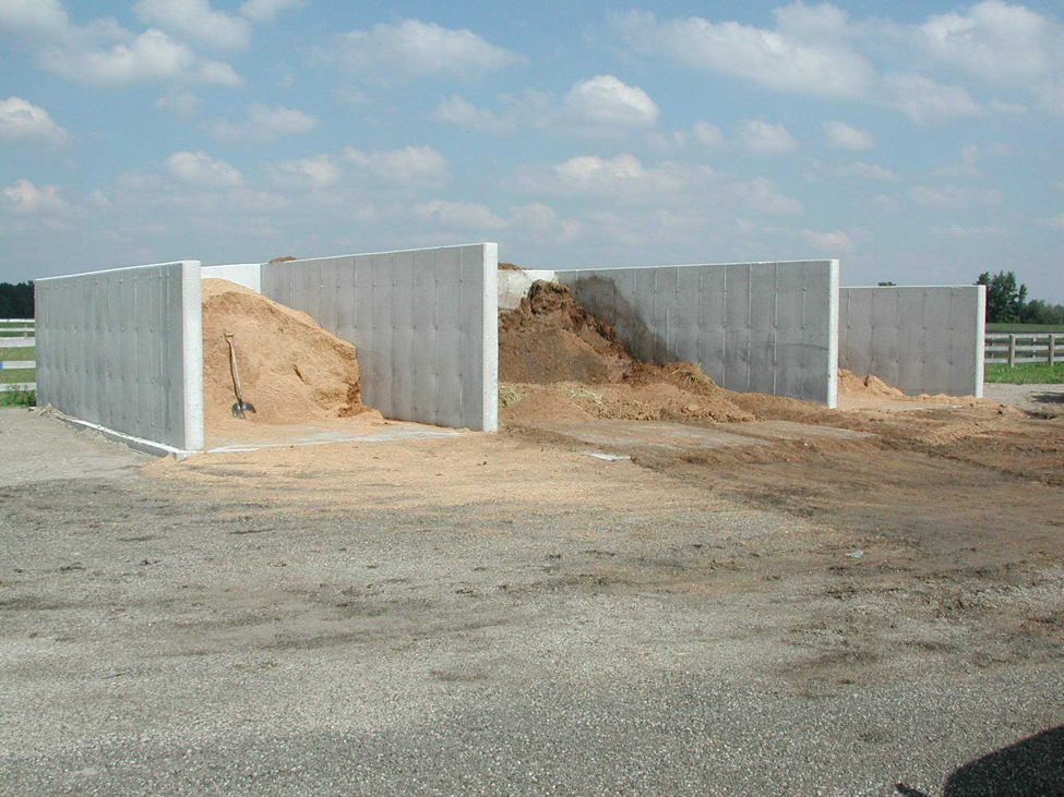 Cette photo montre une structure à murs en béton, qui peut servir à entreposer du fumier. La structure de bunker est divisée en trois sections et ne comporte aucun toit.