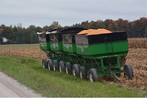 Four gravity wagons strung together in a field.