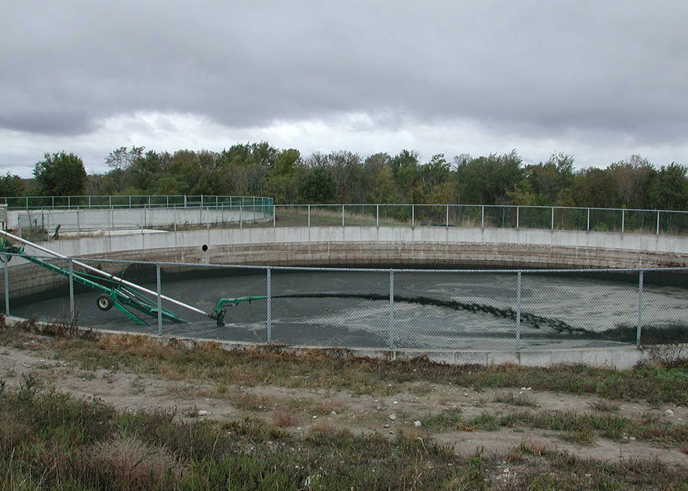 Figure 6.	Photo d’une pompe qui agite du fumier liquide d’une structure de stockage en béton de forme circulaire entourée d’une clôture.