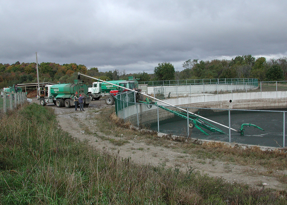 Figure 7.	Photo qui montre le remplissage de camions-citernes après l’agitation du fumier dans une structure de stockage enfouie de forme circulaire.