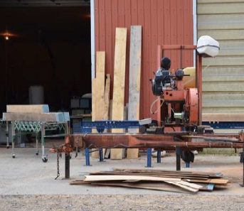 Portable sawmill for processing rough windbreak logs into dimensional lumber.
