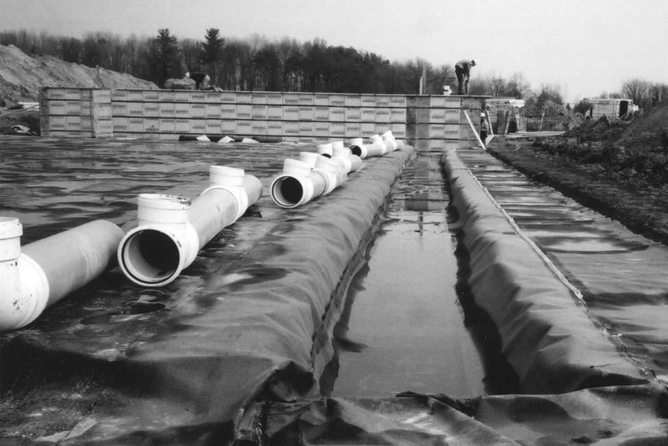 Photo de sections de tuyaux à côté d’une tranchée, prêtes pour l’assemblage. Les tuyaux formeront un système sûr de transfert de fumier liquide depuis le réservoir situé dans le futur bâtiment d’élevage jusqu’à la structure extérieure d’entreposage du fumier.