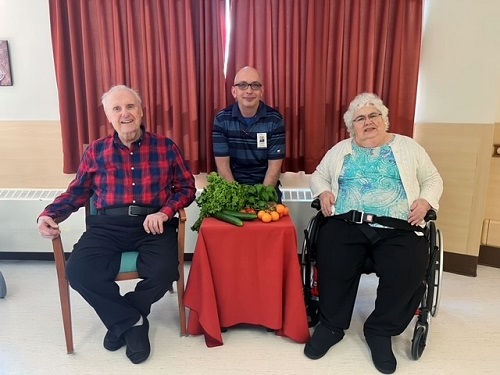 Photo of Chris Borutski and residents, Marie and Ignit Stetsko holding some of the fresh produce they bought from Debruin’s Greenhouse in Thunder Bay.