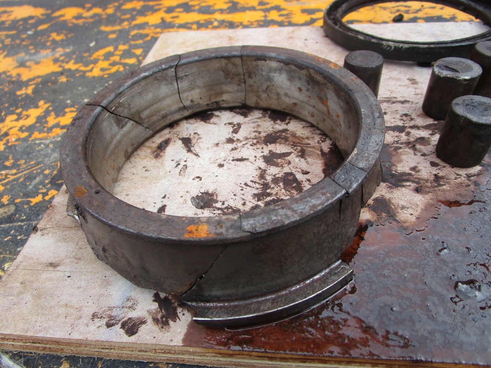 broken hoist reduction gear output shaft bearing components (race and rollers) that were retrieved from the bottom of the housing of the hoist reduction gear