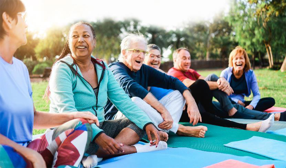 Seniors in a park doing yoga.