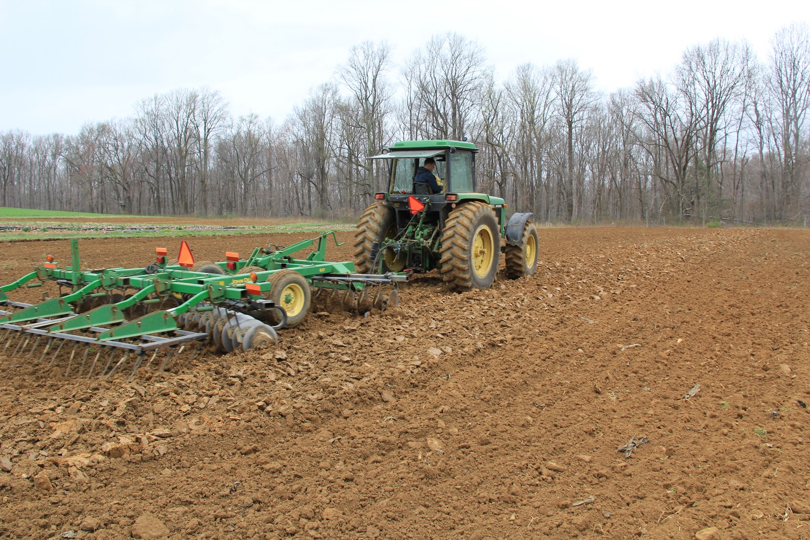 Tractors tilling up and down on a sloped field