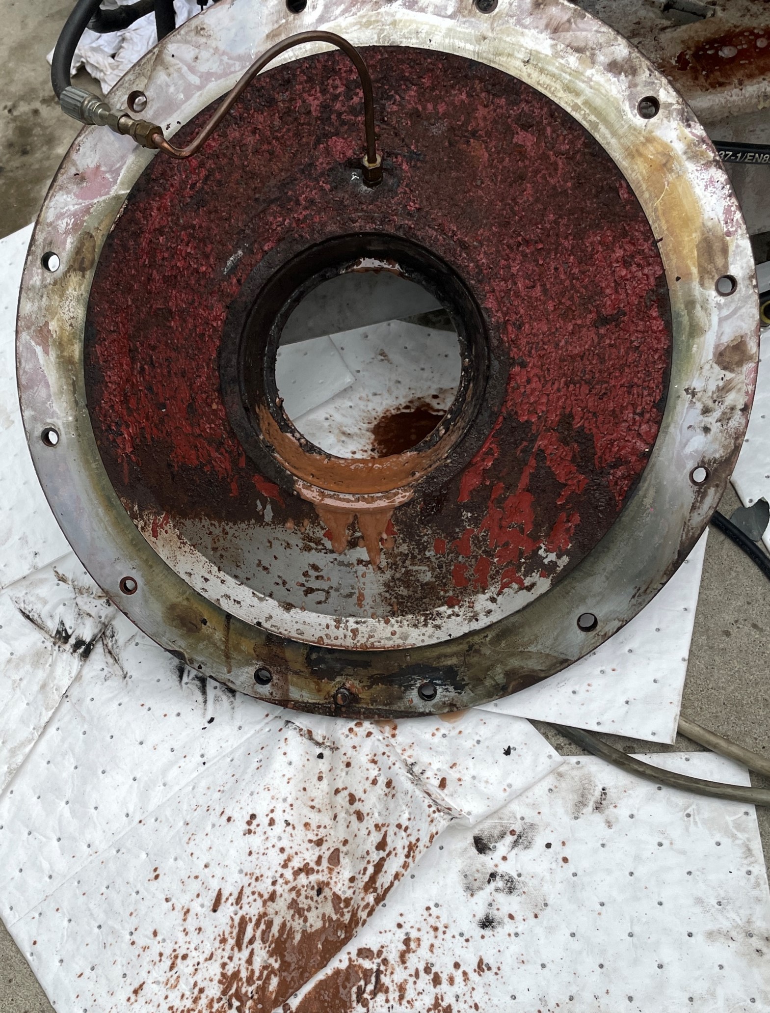 La bride qui abrite le roulement à rouleaux qui supporte la sortie principale est enlevée. Une pression a été appliquée au système de lubrification pour éliminer le blocage dans l’orifice obstrué. On voit le liquide contaminé s’écouler du système de lubrification une fois que l’orifice obstrué est dégagé