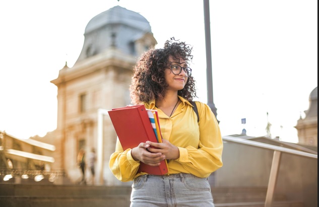 A person holding books and smiling