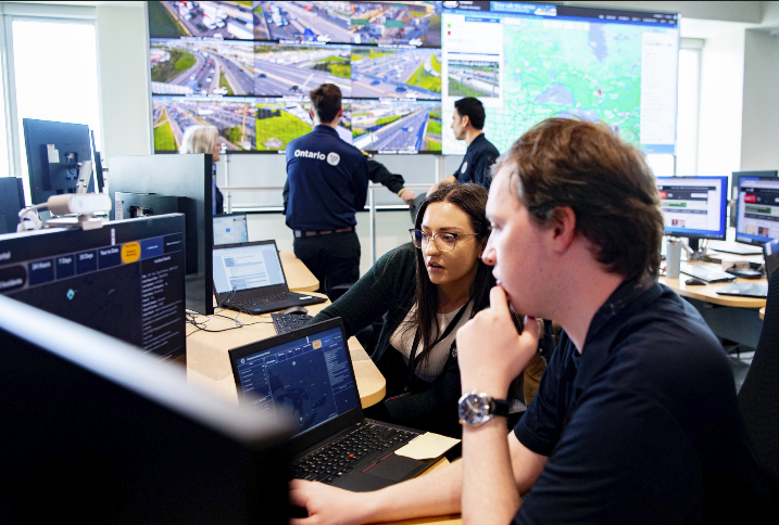 Two people sitting in front of an Emergency management Ontario screen.