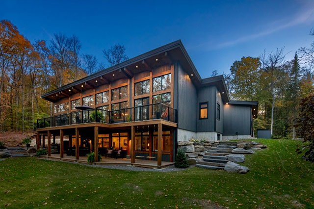 Une grande maison avec une pelouse et des arbres en arrière-plan