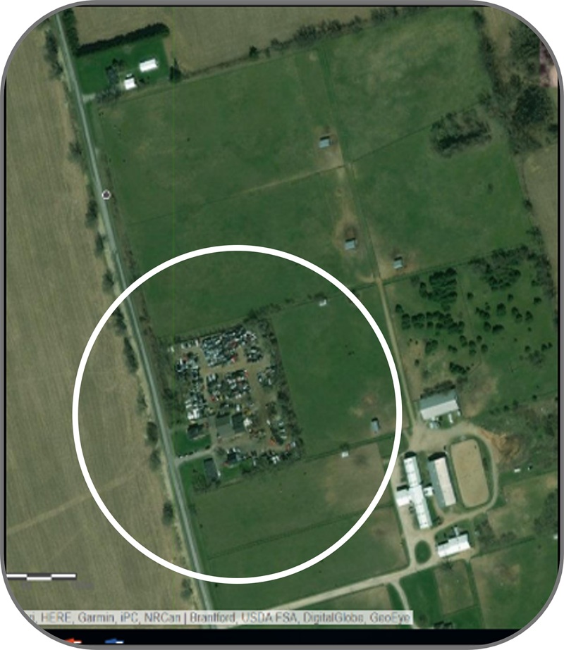 Aerial view of an auto shop surrounded by farmland within a prime agricultural area. A circle highlights the business.